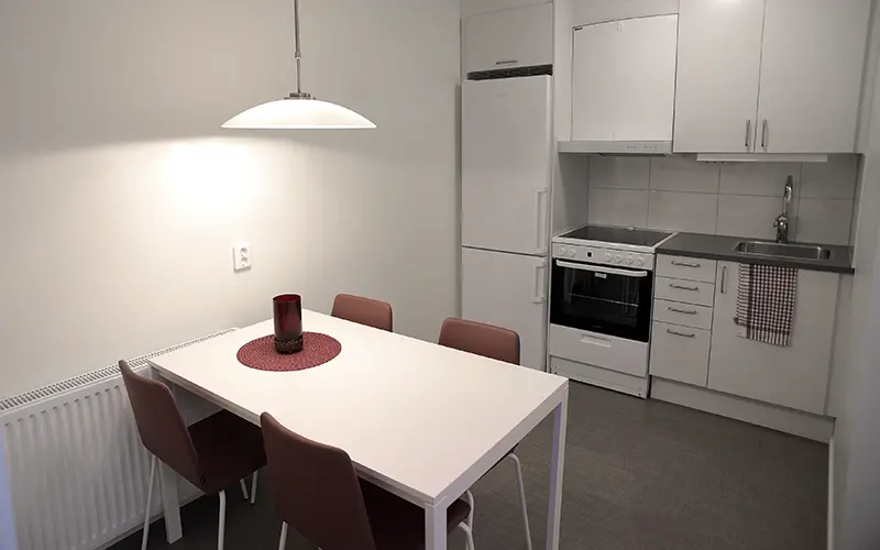 Kök i gästlägenheten med köksbord och frya stolar