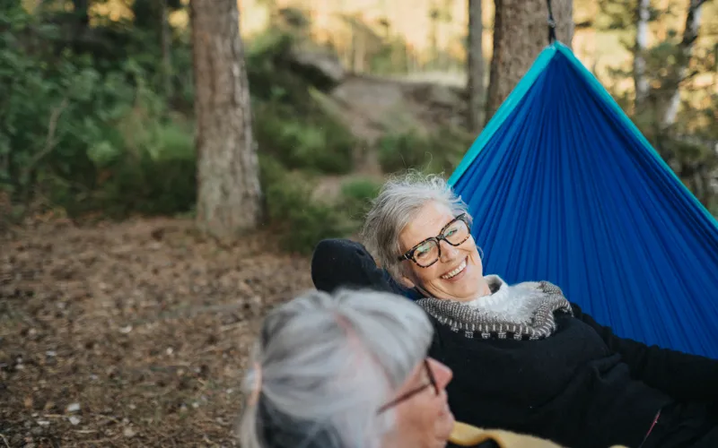 Två kvinnor som sitter i en hängmatta tillsammans.