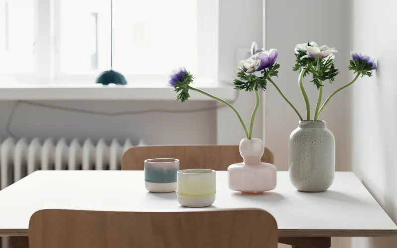 Ett bord med två vaser med blommor på.