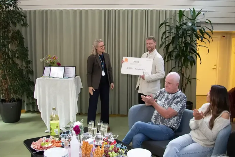 Anchela Signell överlämnar en check till Rasmus Grip som symbol för Övikshems sponsringsengagemang av Kulturskolan
